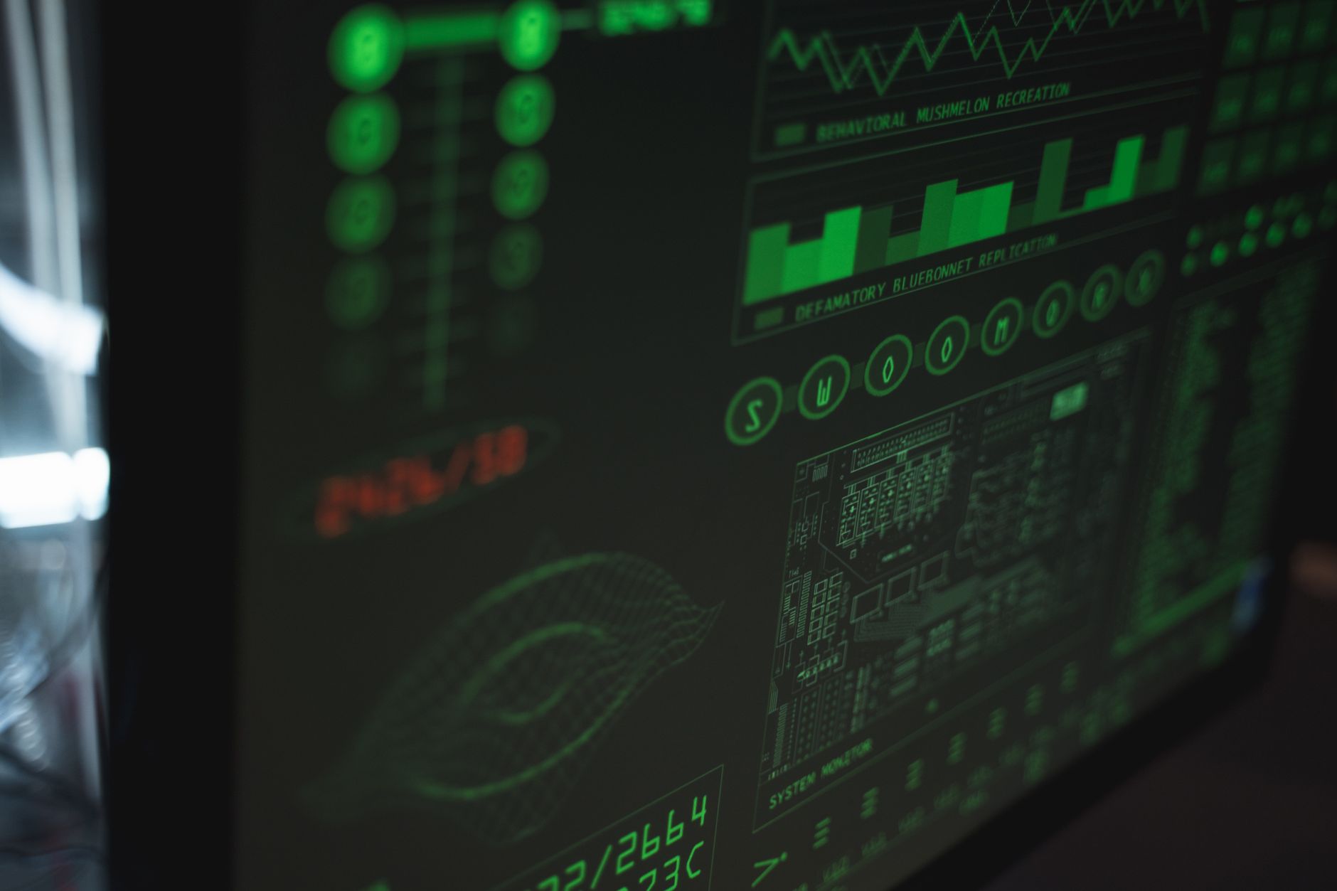 Ekran monitora wyświetlający zielone dane, wykresy i wskaźniki systemu monitoringu