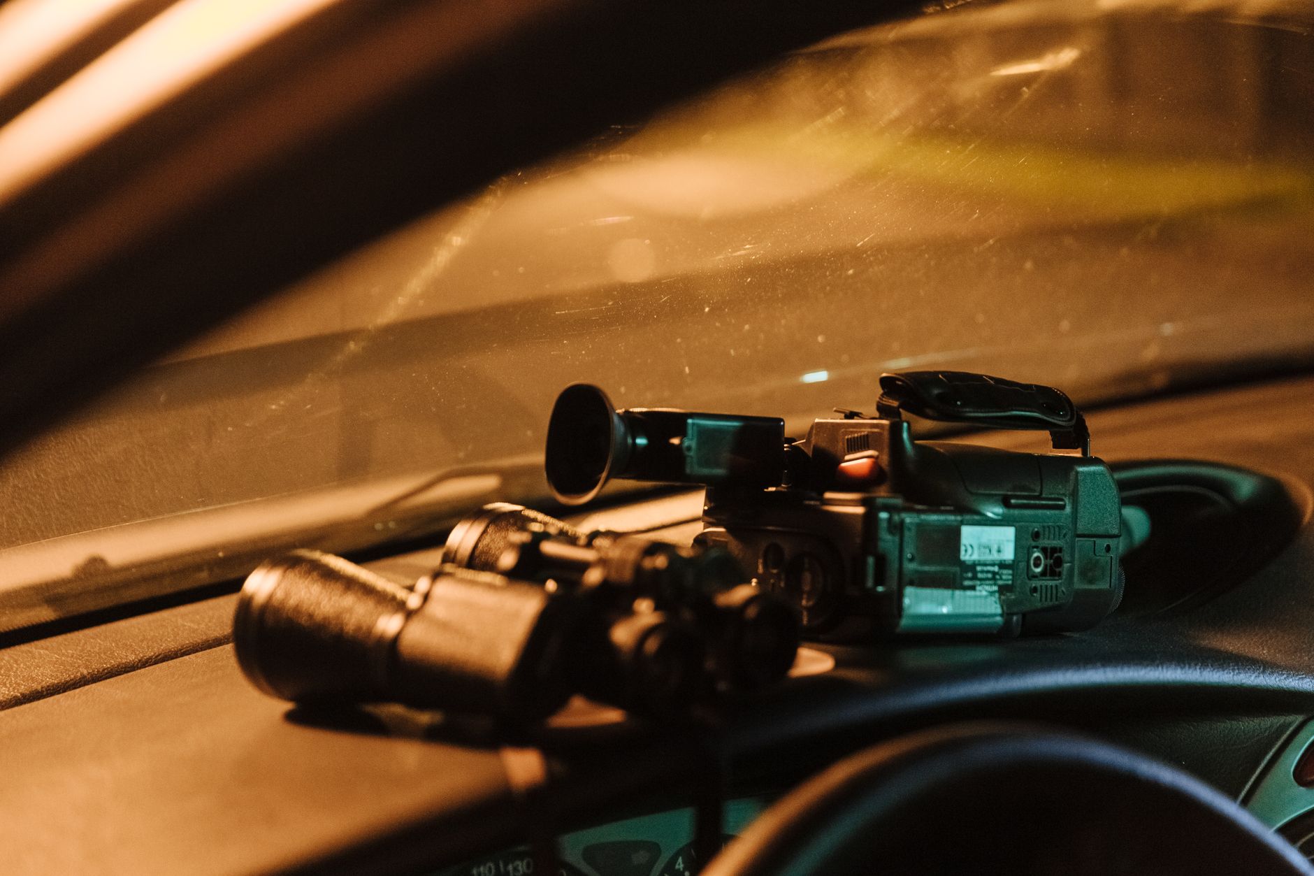 Kamera wideo i urządzenie GPS z przewodami ułożone na desce rozdzielczej samochodu